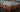 Numerous sealed Mason jars filled with homemade apple butter arranged in neat rows on a wooden table