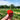 A close-up hand holding a fresh, bright red strawberry with a field background.