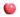 A shiny, bright pink-red apple with a smooth surface, isolated against a dark checkered background.